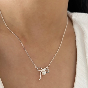 Collier élégant en argent 925 avec pendentif nœud et perle blanche porté par un mannequin