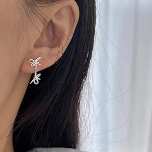 Elegant S925 sterling silver double ribbon bow earrings shown on a model