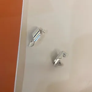 Macro detail of 925 sterling silver twisted ribbon stud earrings with a glossy mirror finish