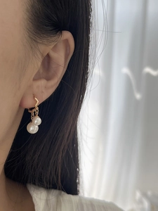 Eleganti orecchini in argento 925 dorato con doppie perle indossati da una modella
