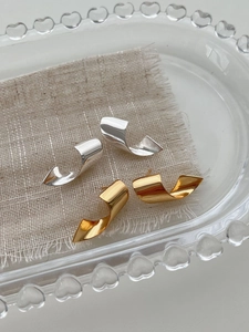 Detailed close-up of 925 sterling silver twisted C-shape earrings in gold and silver