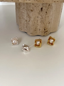 Close-up of gold and silver square stud earrings with round freshwater pearls