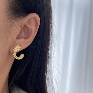 Minimalist gold organic curved C-shape stud earrings on model for a modern look