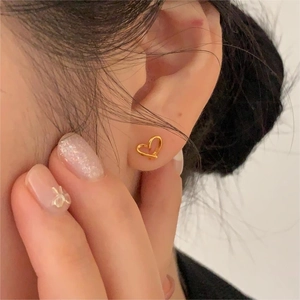 Boucles d'oreilles cœur évidé en argent 925 portées à l'oreille au style élégant