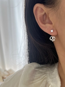 Détails de boucles d'oreilles cœur en argent 925 avec zircons portées par un mannequin