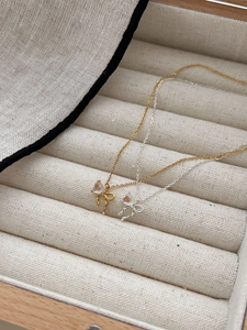 Detail of gold and silver bow necklaces with moonstone pendants in a jewelry box