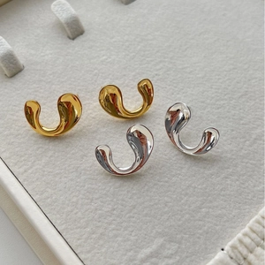 Minimalist U-shaped polished gold and silver metal earrings with organic fluid design