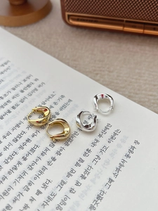 Détail des créoles en argent sterling S925 doré et argenté posées sur des pages