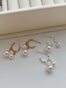 Dettaglio degli orecchini a cerchio in argento 925 con doppie perle pendenti oro e argento