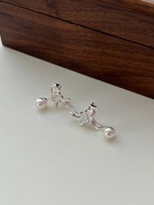 Close-up of S925 silver bow earrings with zircon center and elegant white pearls