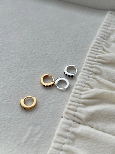 Detail of S925 sterling silver hoop earrings with black zircon pavé in gold and silver