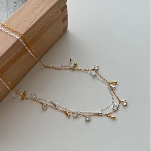 Elegante set di collane a strati in argento S925 con nappe in perla e zirconi su sfondo grigio