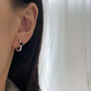 Minimalistische S925 Silber-Creolen mit schwarzem Onyx-Stein am Ohr einer Frau getragen