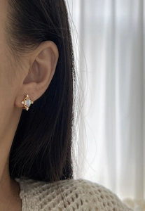 Détail de la boucle d'oreille étoile en argent s925 avec opale sur l'oreille