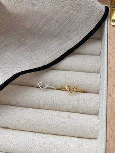 Detailed macro view of heart shaped silver and gold minimalist rings on fabric