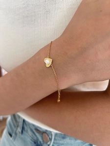 Detail of gold heart pendant with white pearl on 925 silver adjustable chain bracelet