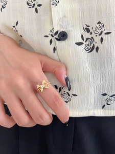Macro shot of gold bow ring with a clear zircon and twisted rope texture on model