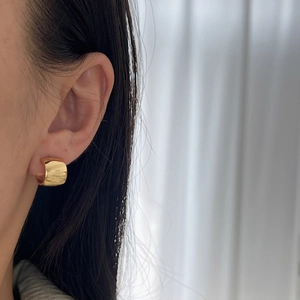 Minimalist chunky gold C-shaped hoop earrings with polished finish shown on model