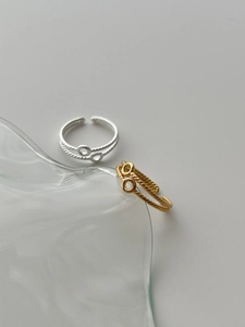 Detail of gold and silver S925 sterling silver rings with twisted spiral wave texture