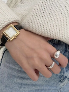 Macro shot of 925 sterling silver water drop and quilted rings with vintage watch