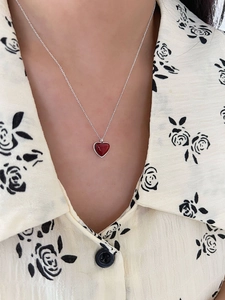 Close-up of a 925 sterling silver heart necklace with red stone pendant on a model