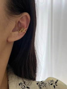Artistic gold origami paper crane ear cuff with brushed texture on female model
