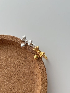 Close-up of S925 sterling silver bow rings with heart pendants in gold and silver