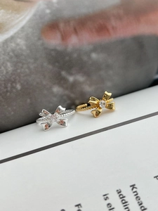 Macro view of gold and silver bow rings featuring twisted bands and zircon centers