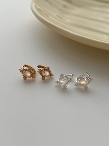 Vue macro de boucles d'oreilles étoile en argent S925 avec pierres de lune irisées
