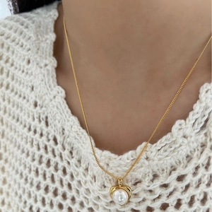 Elegante collana con pendente a cuore dorato e perla bianca su una catena sottile da donna