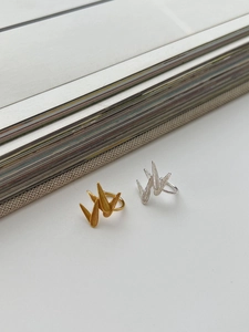 Macro shot of 925 silver bamboo leaf rings with brushed metal texture in gold and silver