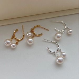 Eleganti orecchini con perle in argento 925 color oro e argento su pelle morbida