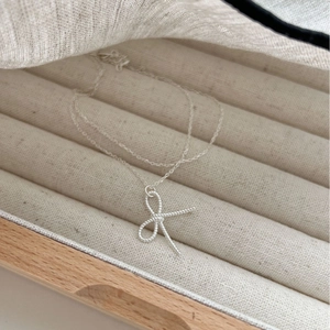 Elegant 925 sterling silver bow knot necklace on a velvet jewelry box display