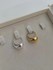 Detailed macro view of gold and silver teardrop rings with mirror polished surface