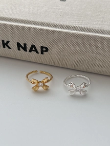 Detailed macro view of 925 silver bow rings in gold and silver with twisted bands