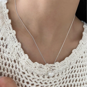Elegante collana con ciondolo a forma di cuore di perle e cornice in argento su una modella