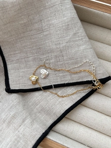 Detail of heart pendants with pearls on gold and silver chains for women