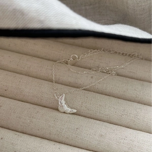 925 Sterling silver croissant pendant necklace with spiral texture on beige velvet