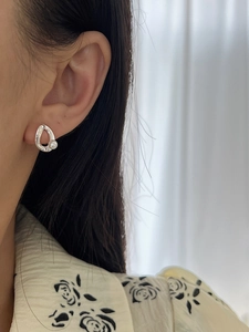 Close-up of minimalist S925 silver irregular hollow earring with natural white pearl