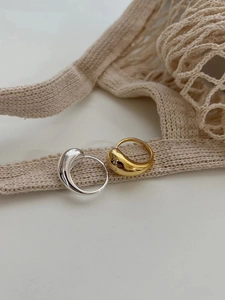 Macro shot of minimalist S925 sterling silver water drop rings in gold and silver finish