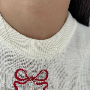 Moonstone bow necklace for women with blue gemstone pendant on white knit sweater
