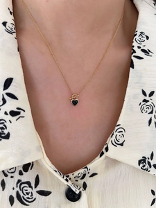 Detail of S925 silver gold necklace with black heart pendant and T-bar toggle clasp
