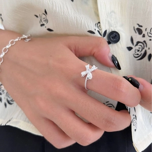 Minimalist 925 sterling silver bow ring with sparkling crystals on female hand