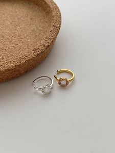 Detail of gold and silver flower ear cuffs with moonstone and cubic zirconia inlays