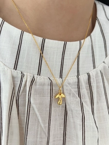 Close-up of a 925 sterling silver mushroom pendant necklace on a model collarbone