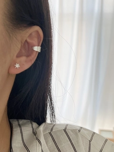 Nahaufnahme der silbernen Earcuff-Schichten und des zarten Schneeflocken-Ohrsteckers
