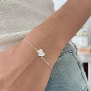 Minimalist 925 sterling silver heart bracelet with a pearl detail on a female wrist