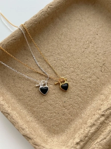 Macro detail of silver heart pendant with black agate and vintage OT buckle toggle closure