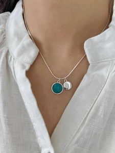 Detailed shot of double pendant 925 silver necklace with turquoise and round silver tag