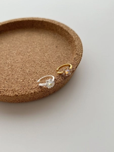 Close-up of gold and silver sunburst ear cuffs with central opal stones and small zircons